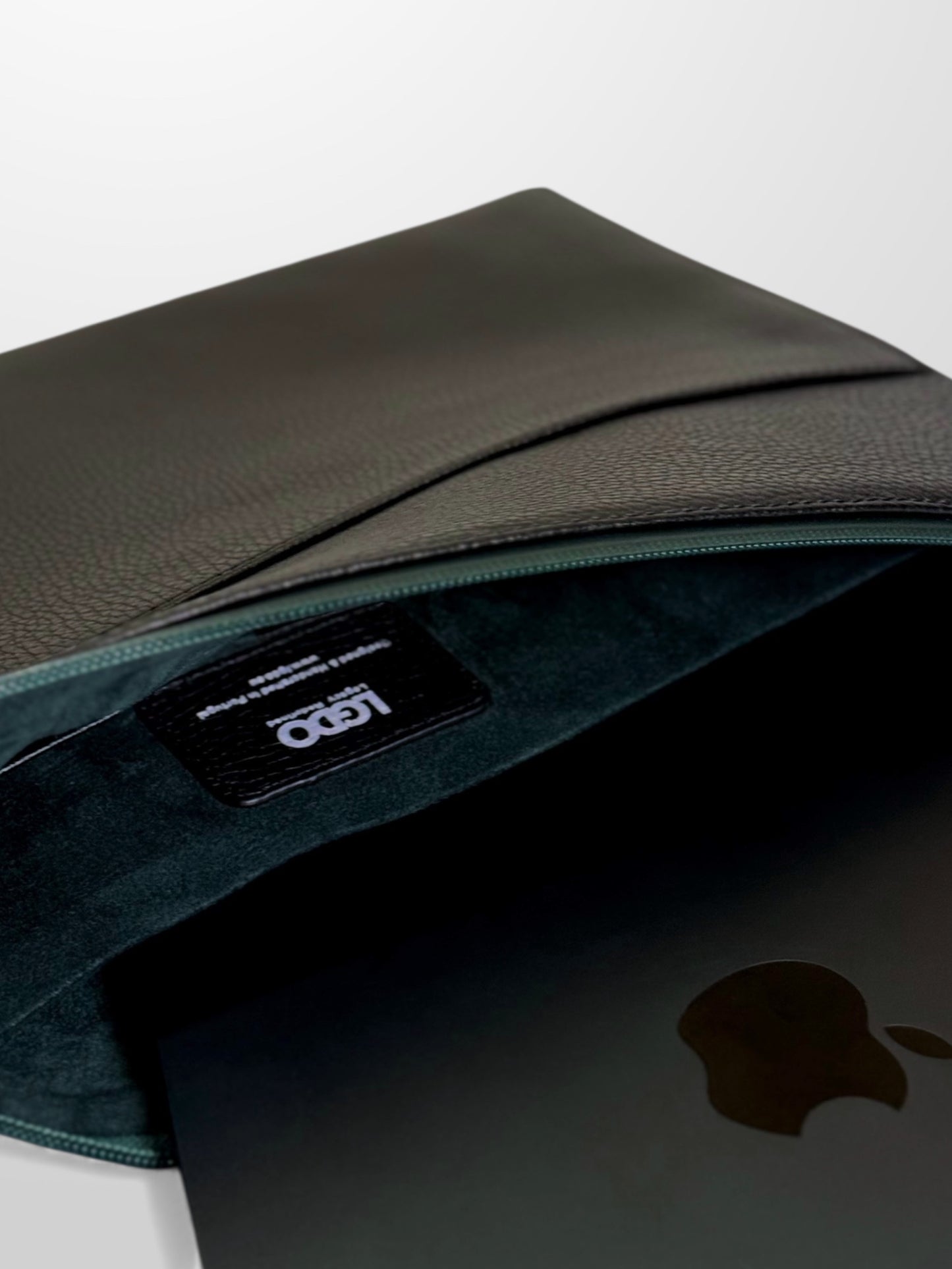 LGDO leather laptop sleeve partially open showing MacBook Air and green microfiber lining