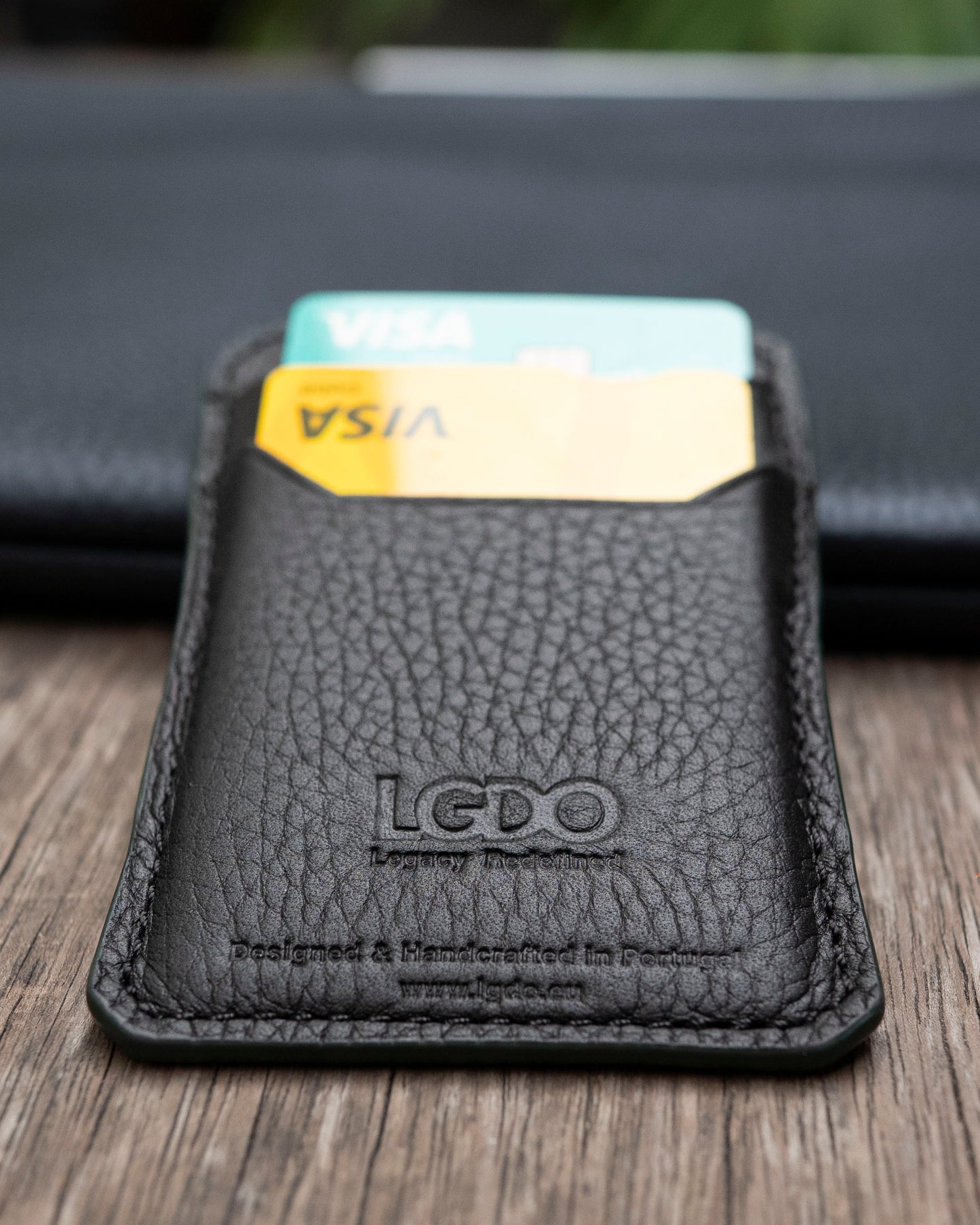 LGDO black leather cardholder close up showing embossed logo and two visible cards